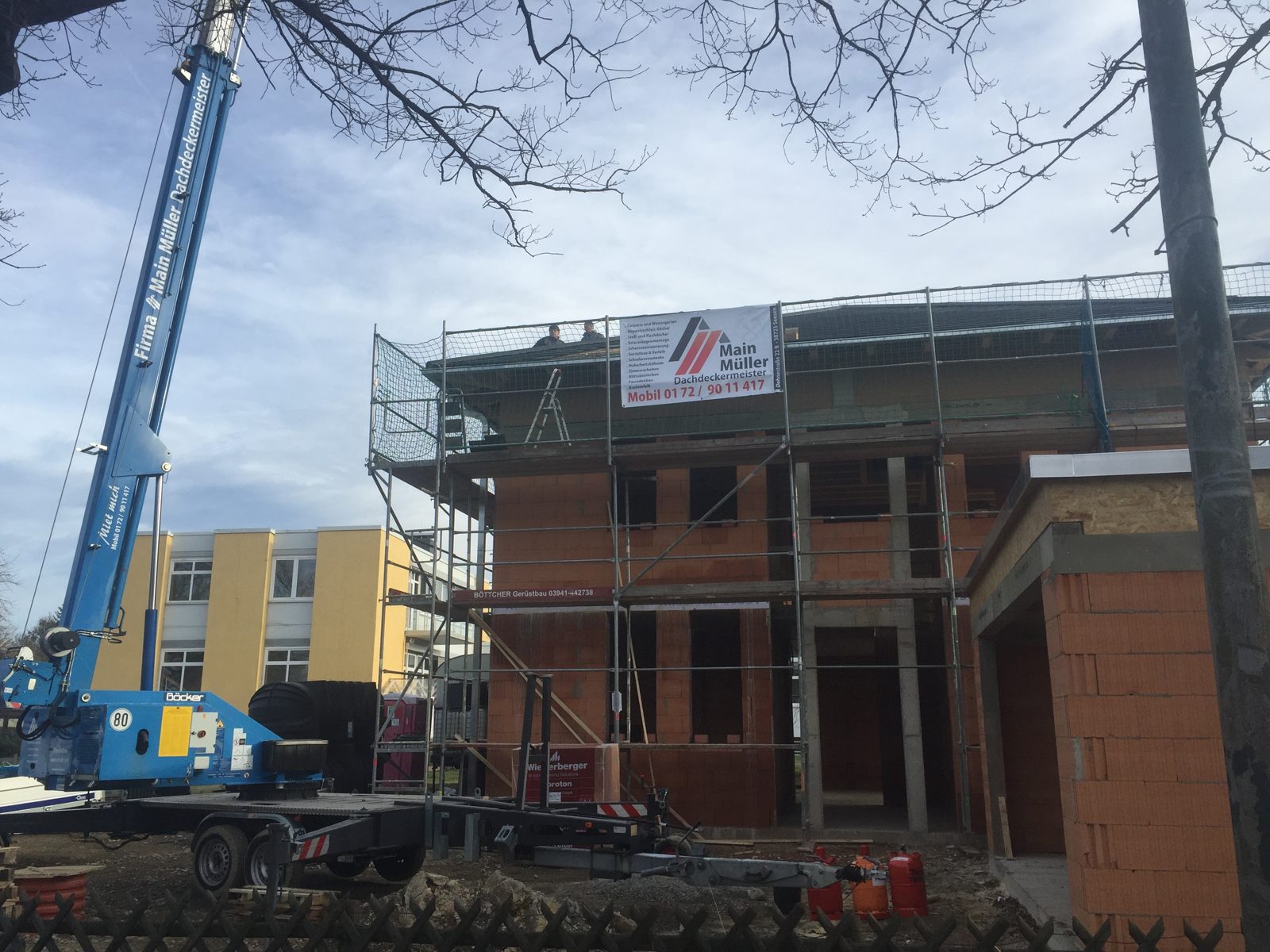 Baustelle der Firma: Gerüst, Hubarbeitsbühne und Banner von Main Müller Dachdeckermeister